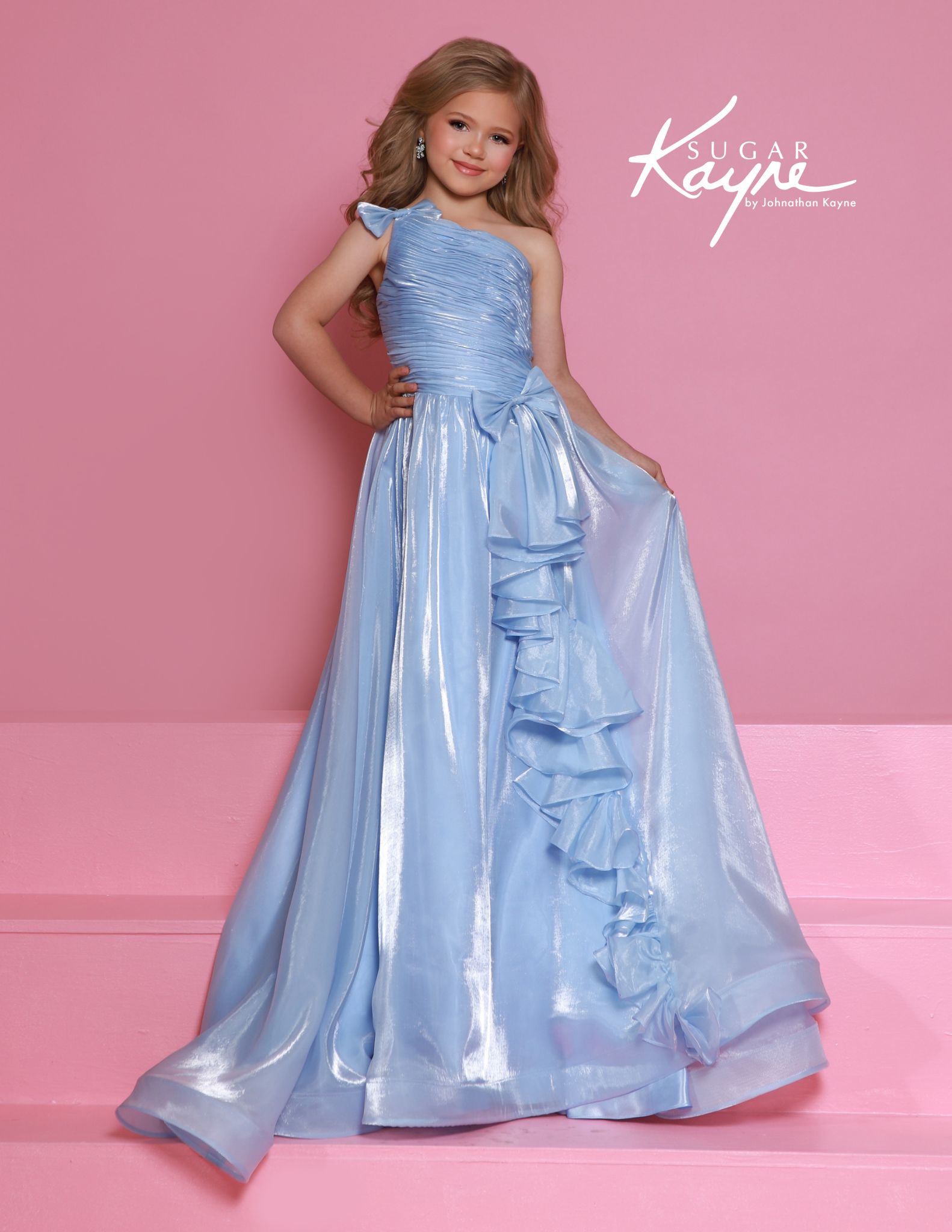Light baby blue one-shoulder gown featuring a ruched bodice, large side bow, and dramatic ruffle skirt.